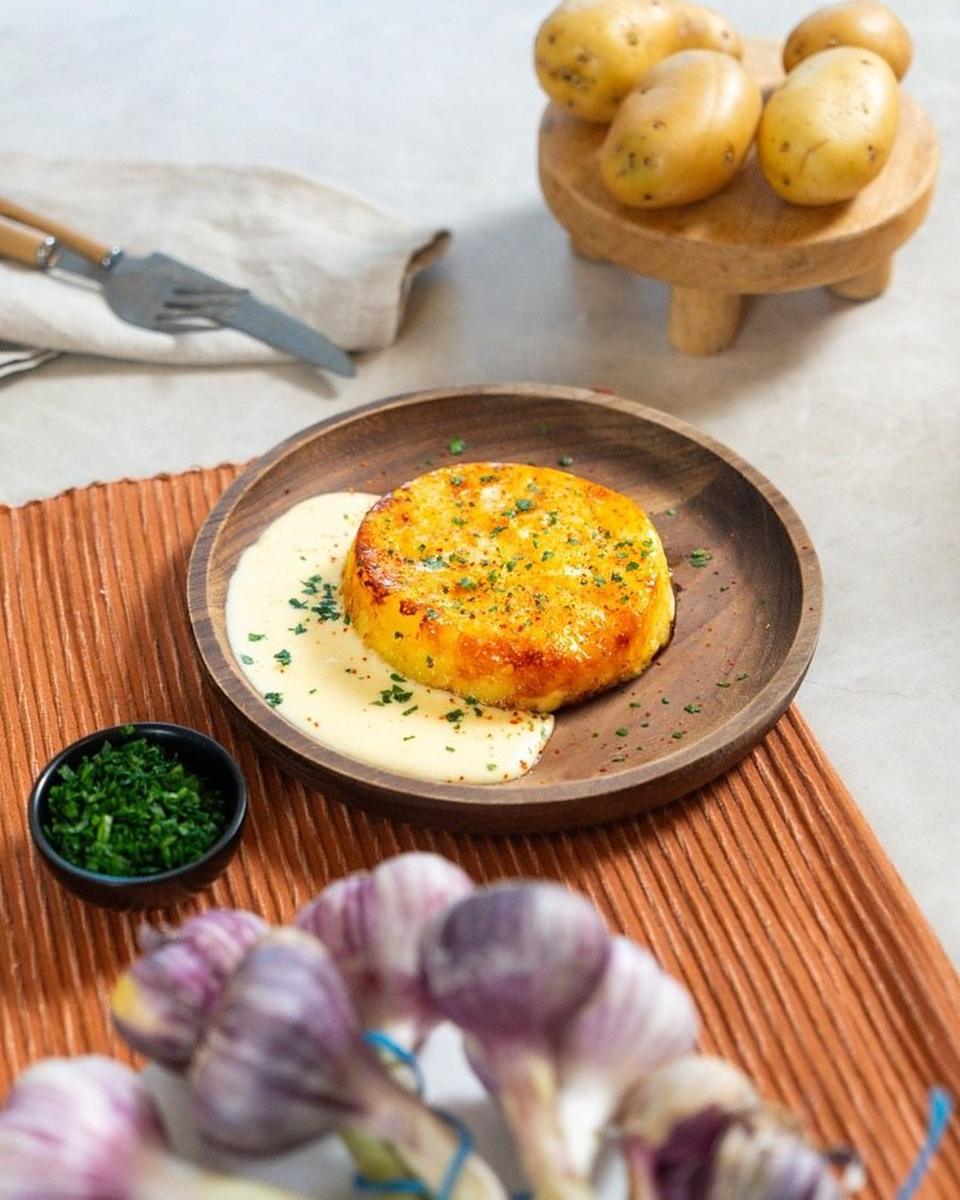 Galette de pommes de terre dorée sur sauce crémeuse, photo culinaire
